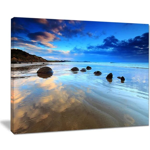 Design Art 'Cloudy Sky Over Moeraki Boulders' Photographic Print on Wrapped Canvas - Size: 20 inch H x 40 inch W x 1 inch D, Blue