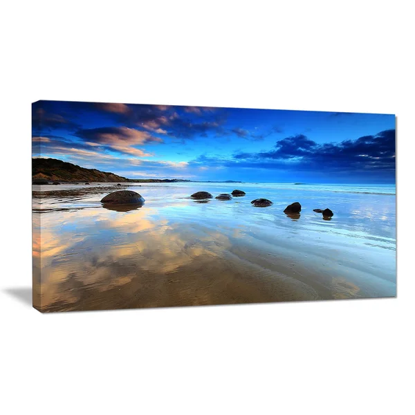 Design Art 'Cloudy Sky Over Moeraki Boulders' Photographic Print on Wrapped Canvas - Size: 20 inch H x 40 inch W x 1 inch D, Blue